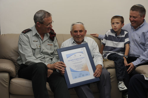 IDF soldiers, including former IDF Chief of the General Staff Lt. Gen. Benny Gantz (left), visit with a Holocaust survivor as part of the "Flower for a Survivor" project. Photo: IDF.