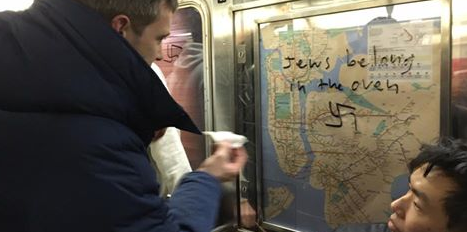 New Yorkers wiping swastika graffiti off subway ads. Photo: Facebook.